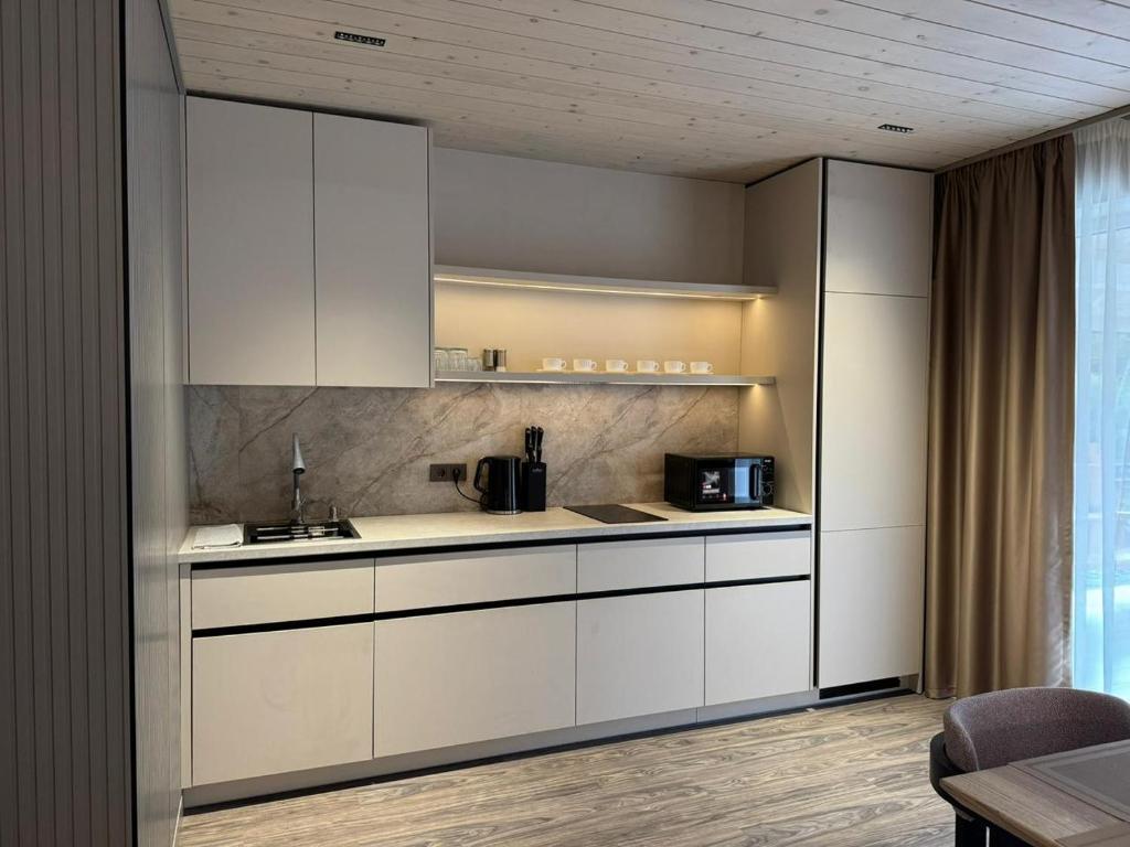 a kitchen with white cabinets and a sink at Mizhhirya resort in Mizhhirya