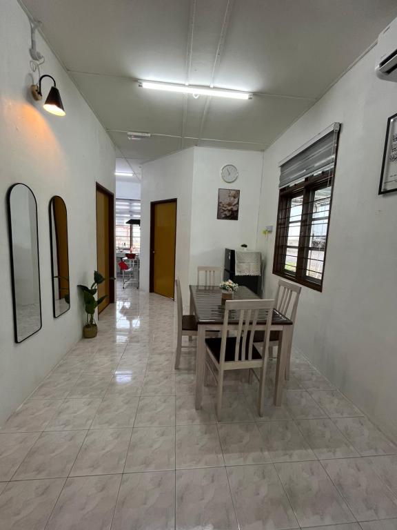 a dining room with a table and chairs at Santai DPermai Homestay in Selama