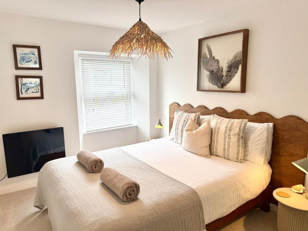 ein Schlafzimmer mit einem Bett, auf dem zwei Handtücher liegen in der Unterkunft Palms 2 - Central, 5 mins walk to beach + parking! in Newquay