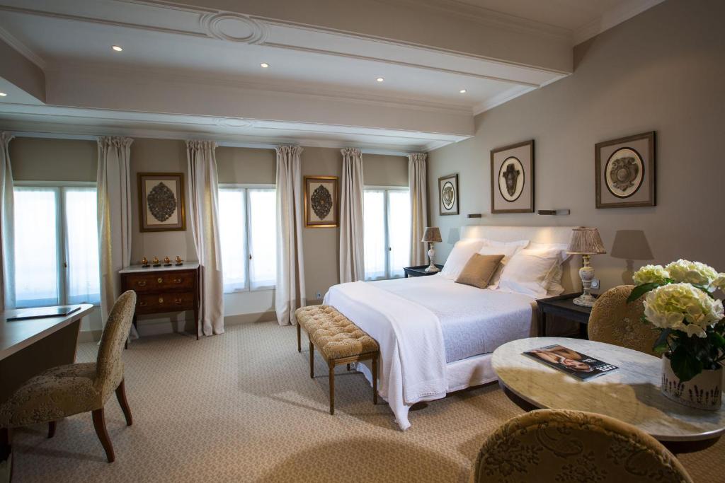 een slaapkamer met een bed en een tafel en stoelen bij Hotel d'Europe in Avignon