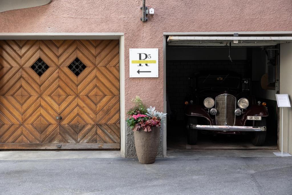 a car is parked inside of a garage with a door at Hotel R5 Budget - Chur in Chur