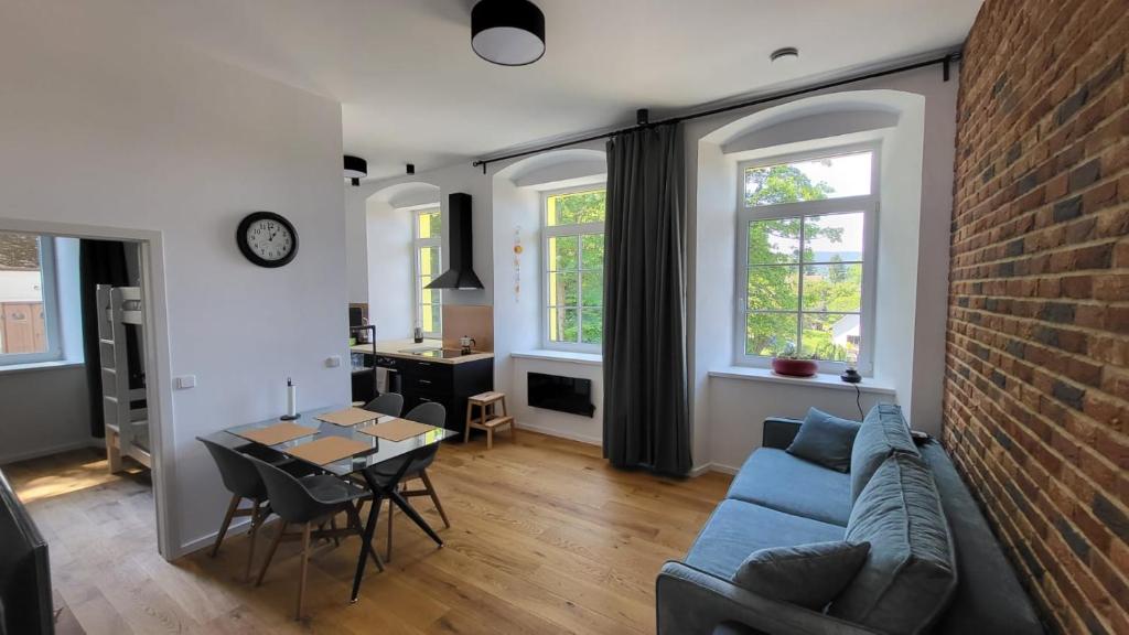 a living room with a blue couch and a brick wall at Šumavská pohoda Zdíkovec 21 in Zdíkov