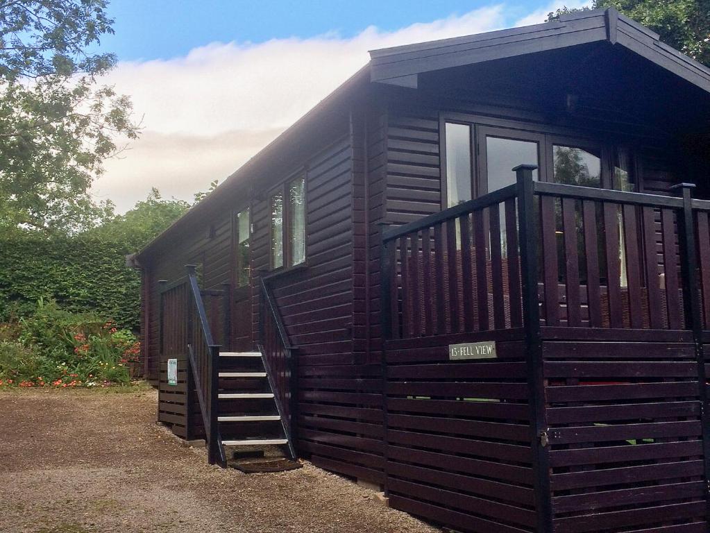 a wooden cabin with a staircase in front of it at Fell View Lodge in Keswick
