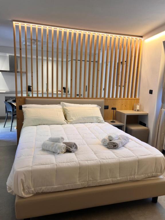 ein Schlafzimmer mit einem großen Bett, auf dem Handtücher liegen in der Unterkunft Curt di Manai Charme Apartments in Tirano