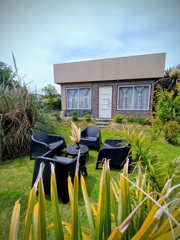 a garden with chairs and a house in the background at Casa Parvati Chapadmalal in Chapadmalal