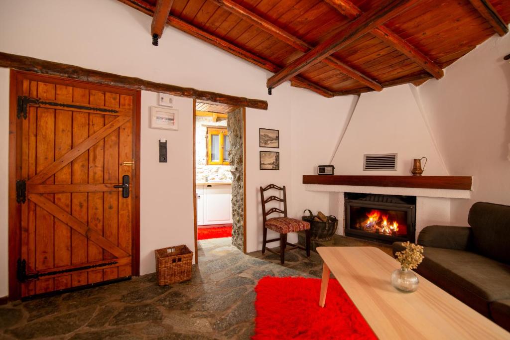 a living room with a wooden door and a fireplace at Fteri Stone House in Platanos, Akrata in Plátanos