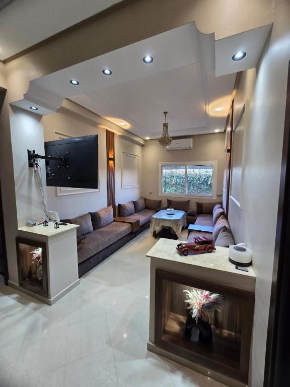 a living room with a couch and a tv at Confort & Emplacement, Pieds dans l'eau in Mansouria