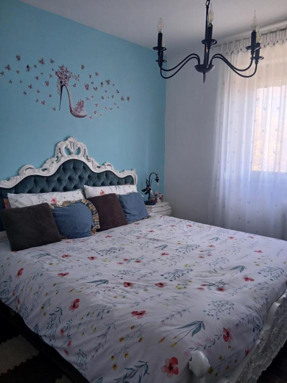 a bedroom with a large bed with a blue wall at Casa Aurora Nicole in Pergine Valsugana