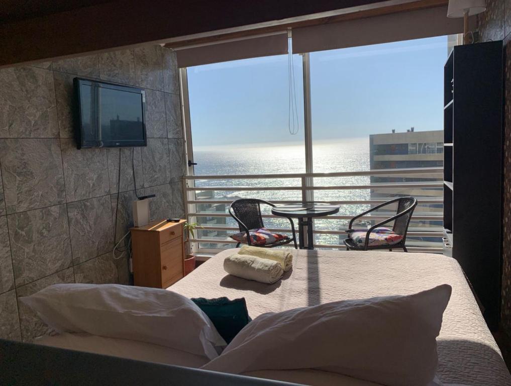 a bedroom with a bed with a view of the ocean at Pingel Apartment Vista Mar in Viña del Mar