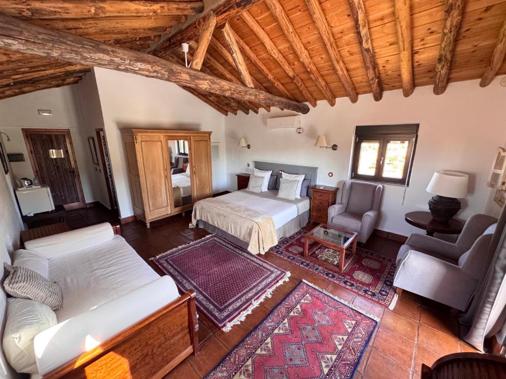 ロンダにあるLa Guzmana de Rondaのベッドとソファと椅子のある寝室