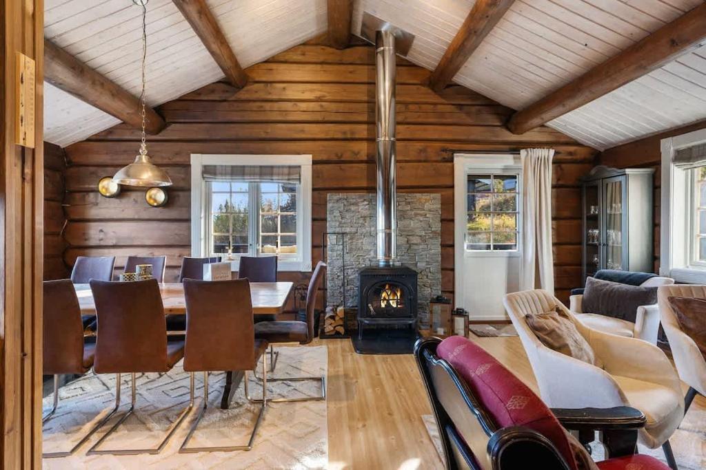a dining room with a table and a fireplace at Trysilfjell 615 by Vacation Trysil in Hovi