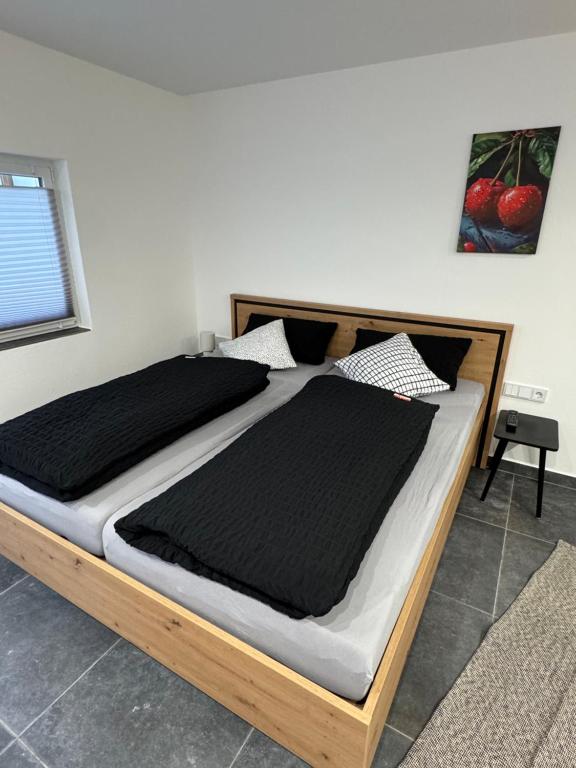 a bedroom with a large bed with black sheets at Ferienwohnung Tee - Time - Lodge und Kirsch - Kiste in Momlingen