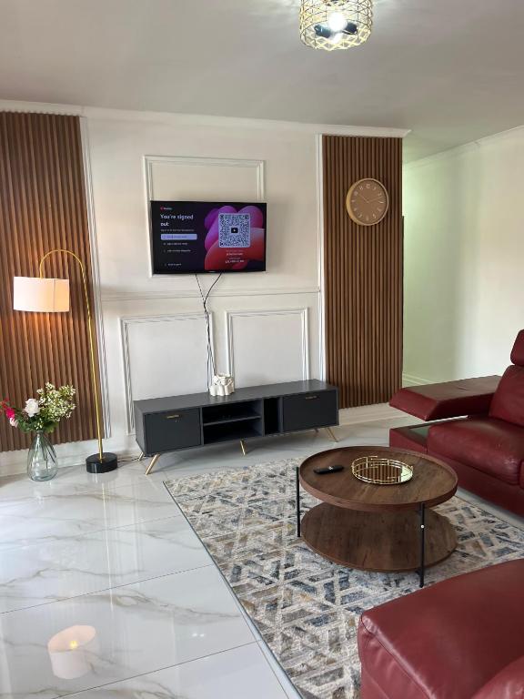 a living room with a couch and a tv at Waterfall Deluxe ll in Rustenburg