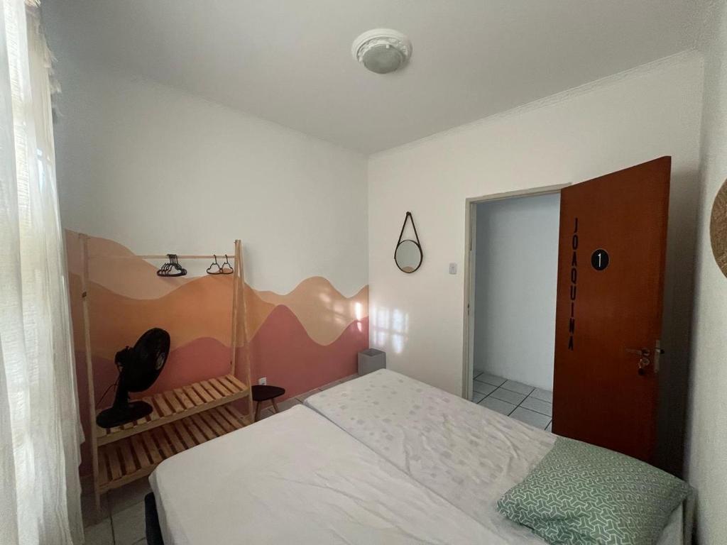 a bedroom with a bed and a door to a room at Voila Hostel in Florianópolis