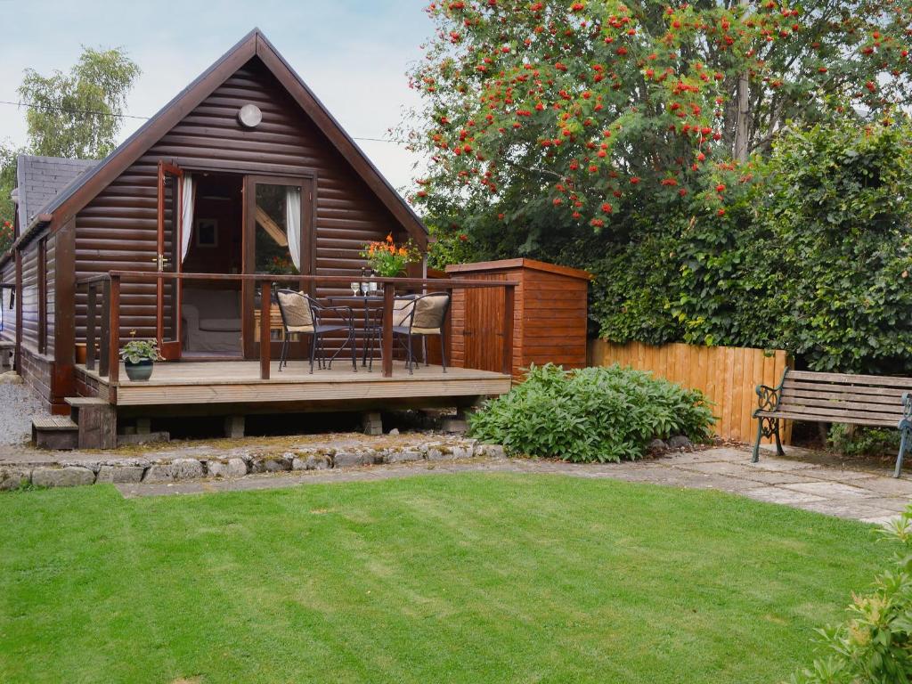 a small cabin with a deck and a bench at Wee Ben in Bridge of Tilt