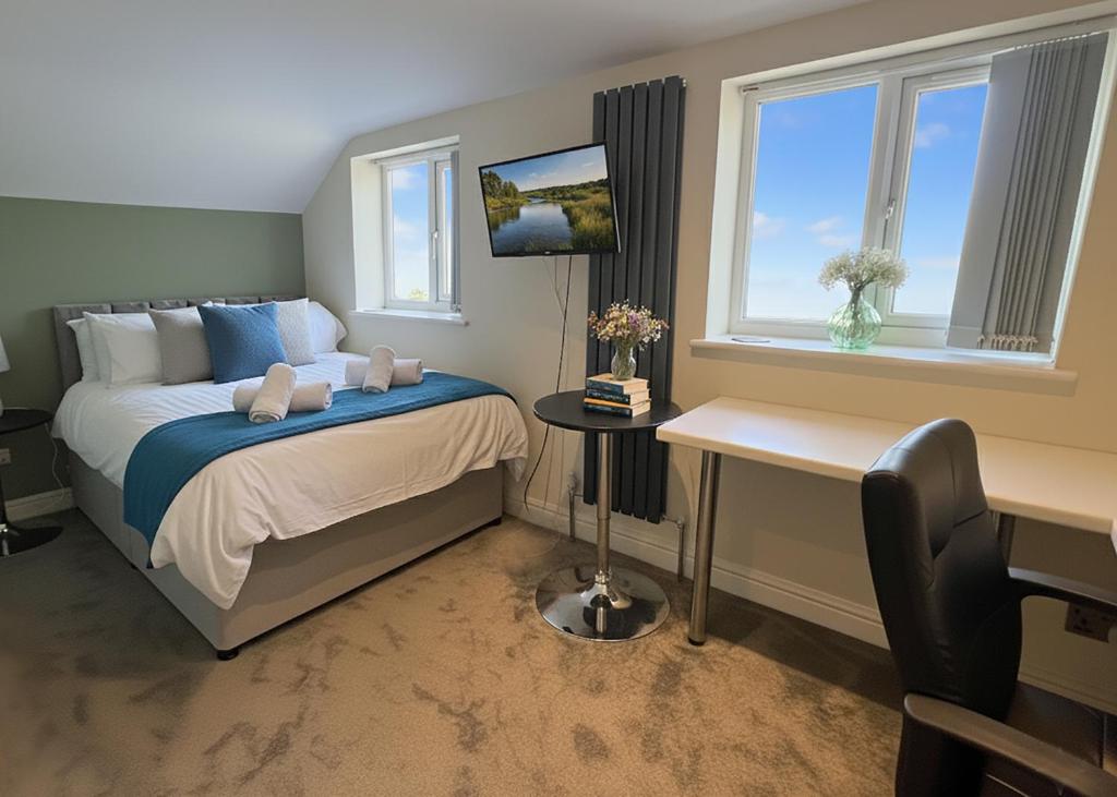 a bedroom with a bed and a desk and a window at Walk to Addenbrookes - Stylish 1 bed Apartment in CBG