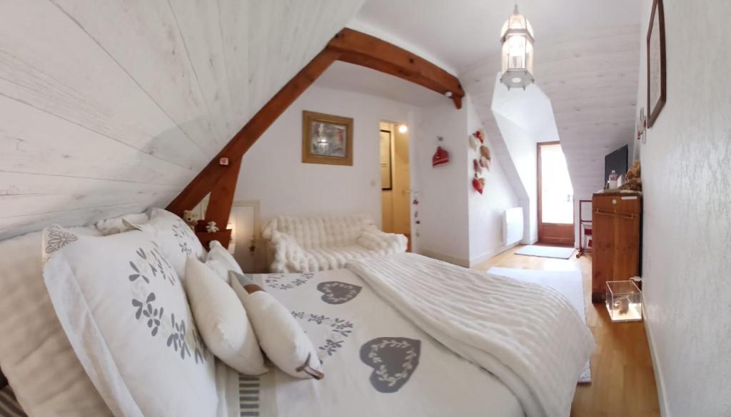a bedroom with a bed with white sheets and pillows at La parenthèse bucolique in Sepmes