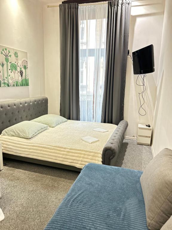 een slaapkamer met een bed, een bank en een raam bij CityGate Kraków in Krakau