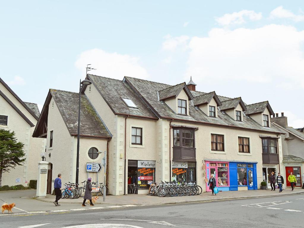 a building on a street with people walking down the street at Herdwick Heights in Keswick