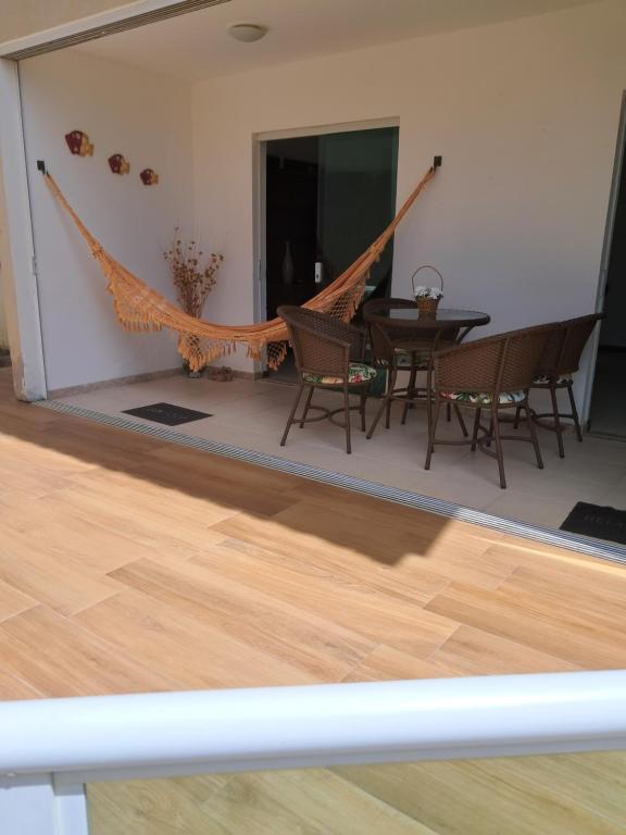 a hammock in a living room with a table and chairs at Casa Recanto de Guarajuba in Guarajuba