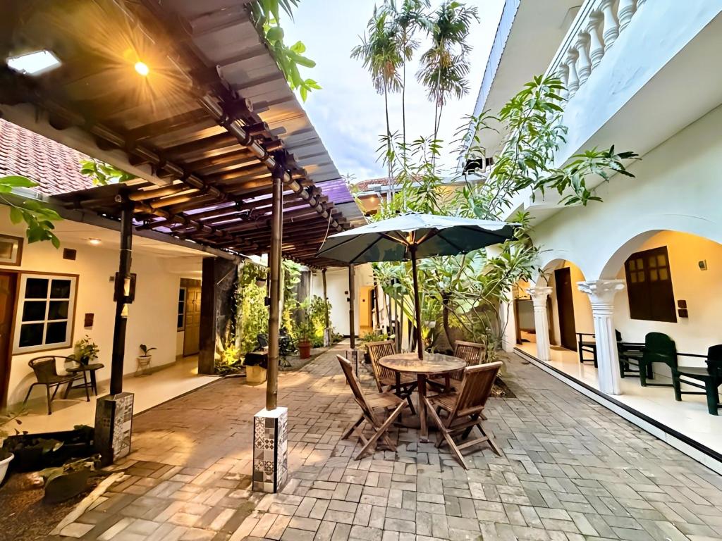 an outdoor patio with a table and an umbrella at The Raden Patah Heritage Kota Lama Semarang in Semarang