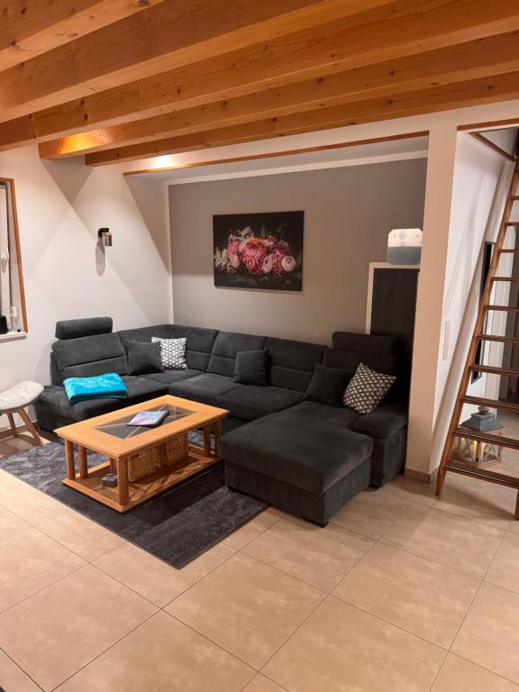 a living room with a black couch and a table at Ferienhaus Fichtenschloss in Salzhausen