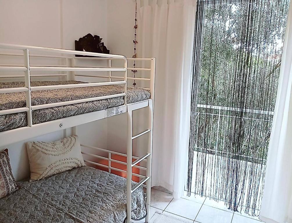 a bedroom with bunk beds and a large window at Artemis sea house in Porto Rafti