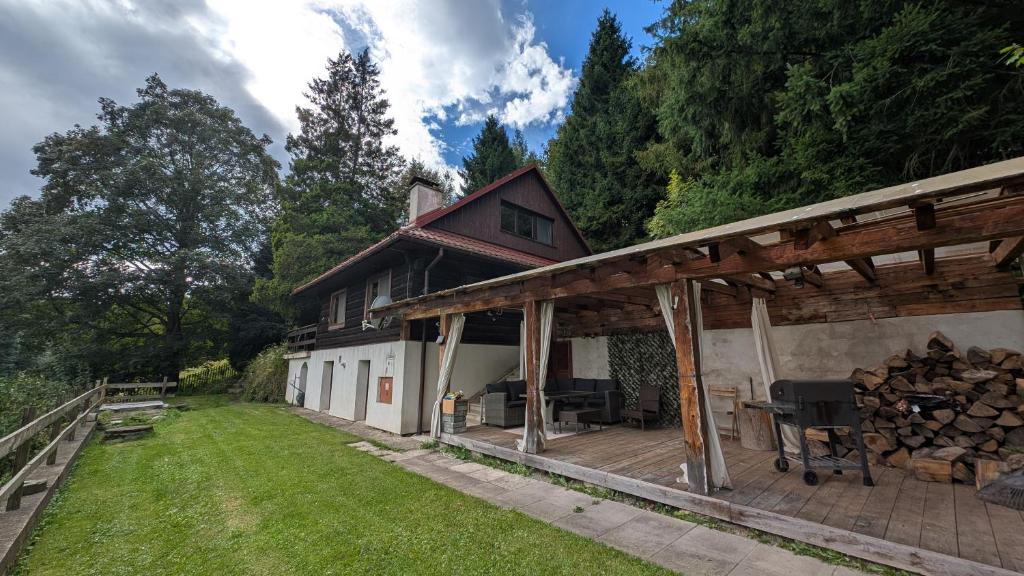 een huis met een terras met een stapel boomstammen bij Chata z Widokiem in Międzybrodzie Bialskie