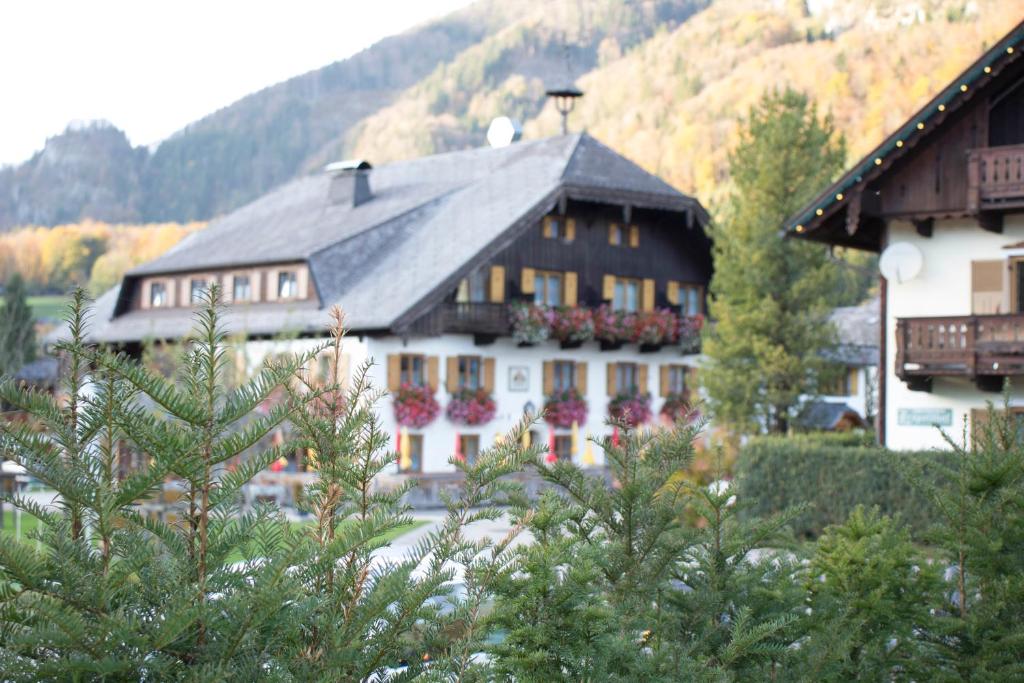 a large white building with a black roof at Landgasthof Leopoldhof in St. Wolfgang