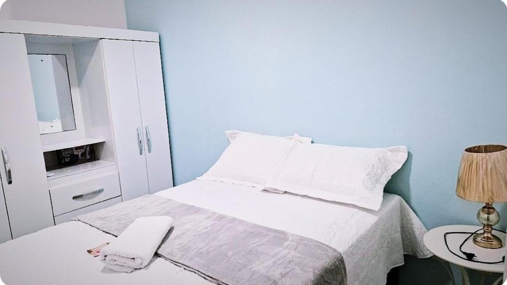 a bedroom with a bed with a phone on a table at Lindo apartamento mobiliado in Ananindeua