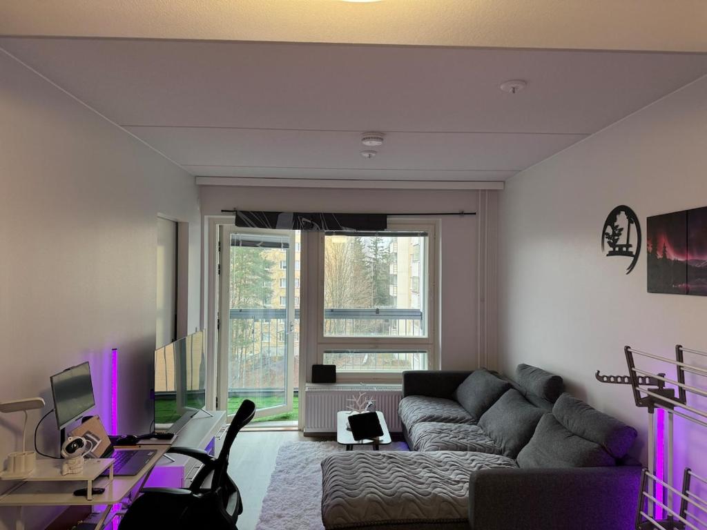 un soggiorno con un divano grigio e un tavolo di Modern & Chic a Vantaa