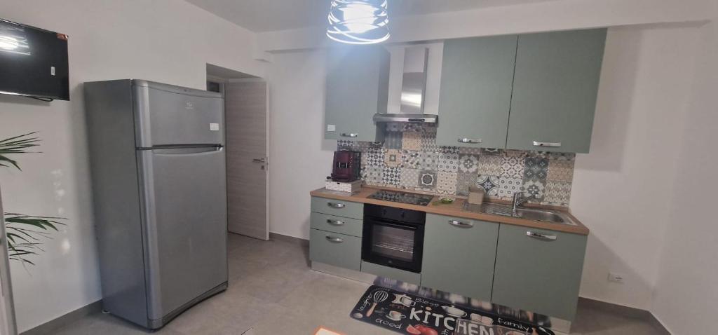 a kitchen with gray cabinets and a refrigerator at B&B Fior di Feruci 