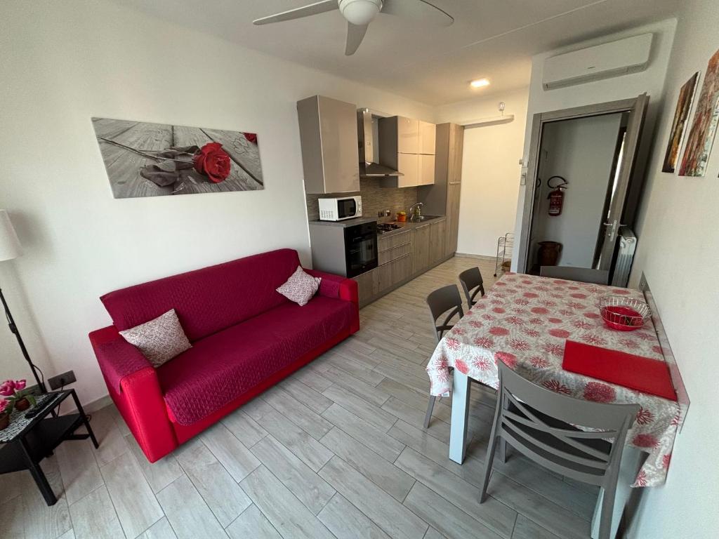 塔贾Appartamento Le Palme的客厅里有一张红色的沙发和一张桌子