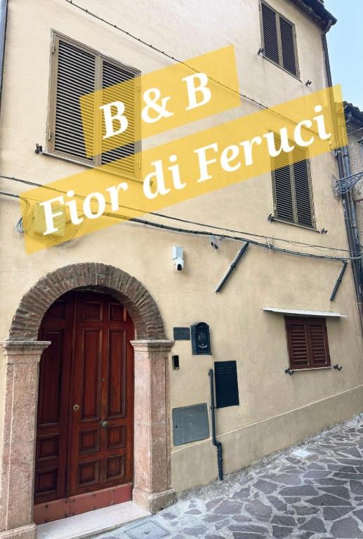 a building with a sign for a store with a door at B&B Fior di Feruci in Trenta