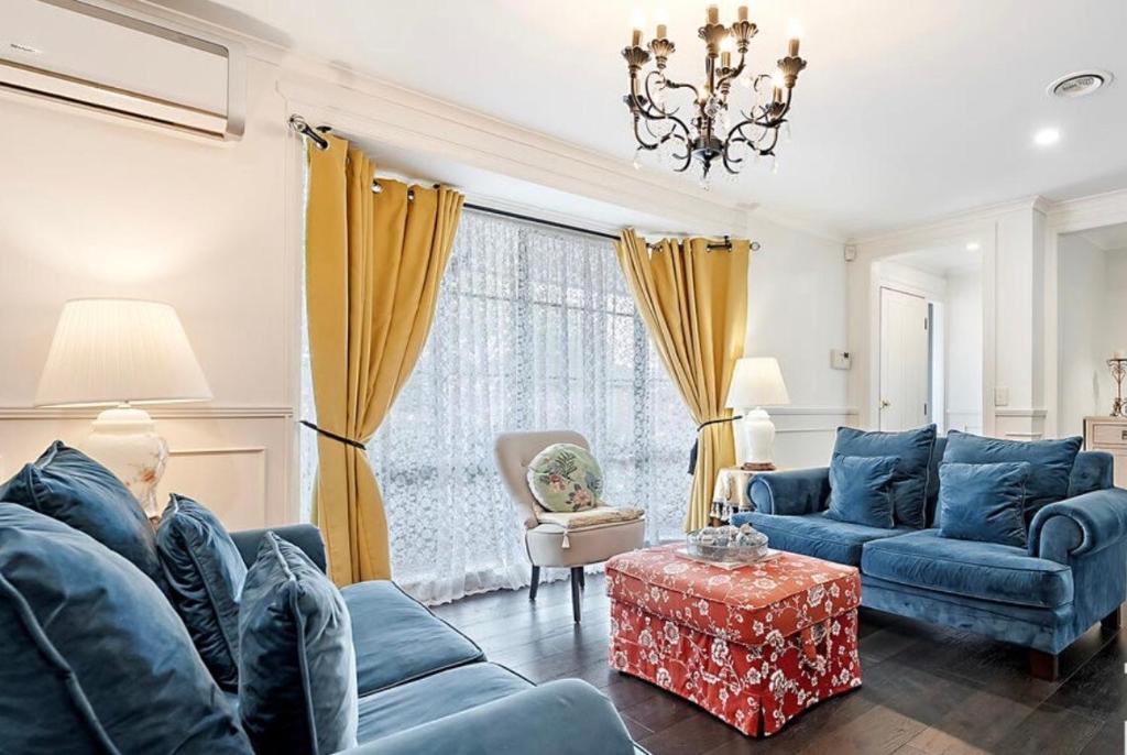 a living room with blue couches and a table at Home of Susan Close in Narre Warren