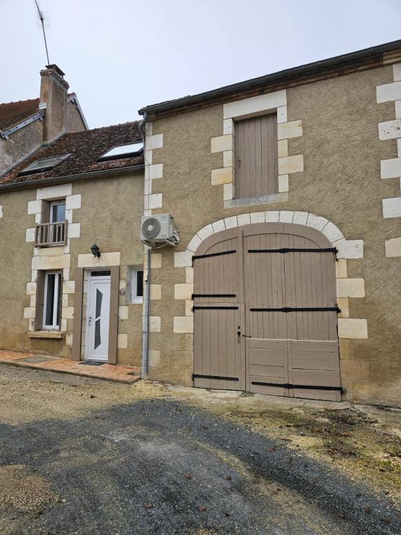 a building with two garage doors on the side of it at Gîte entre vigne et loire in Sancerre