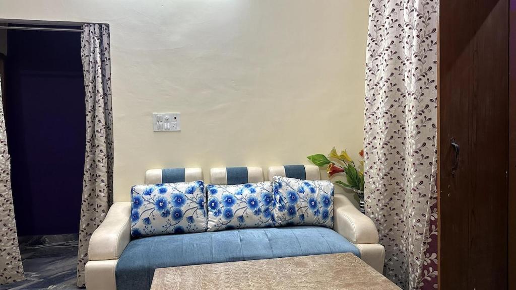 a living room with a couch with blue and white pillows at Varanasi Bliss Stay in Varanasi