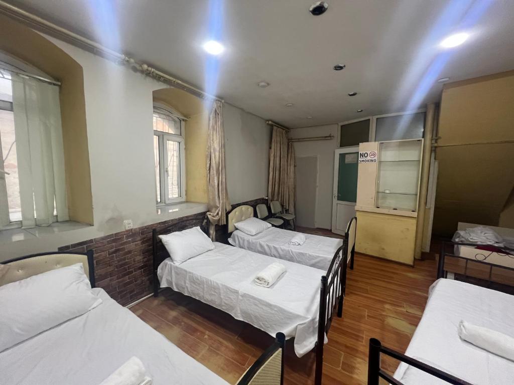 una habitación de hospital con 3 camas y una mesa en Baku View Hostel, en Baku