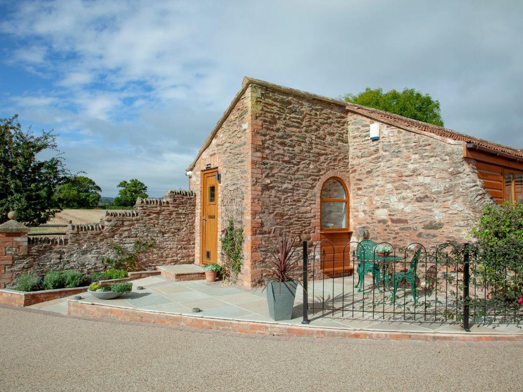 a small brick building with a wooden door at The Linhay in Durleigh