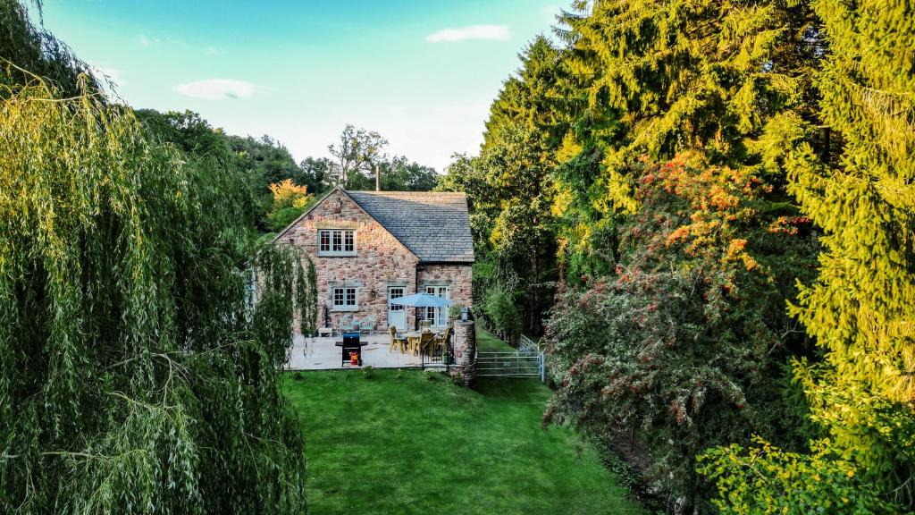 an old stone house in the middle of trees at Flurry's Lodge in Coleford