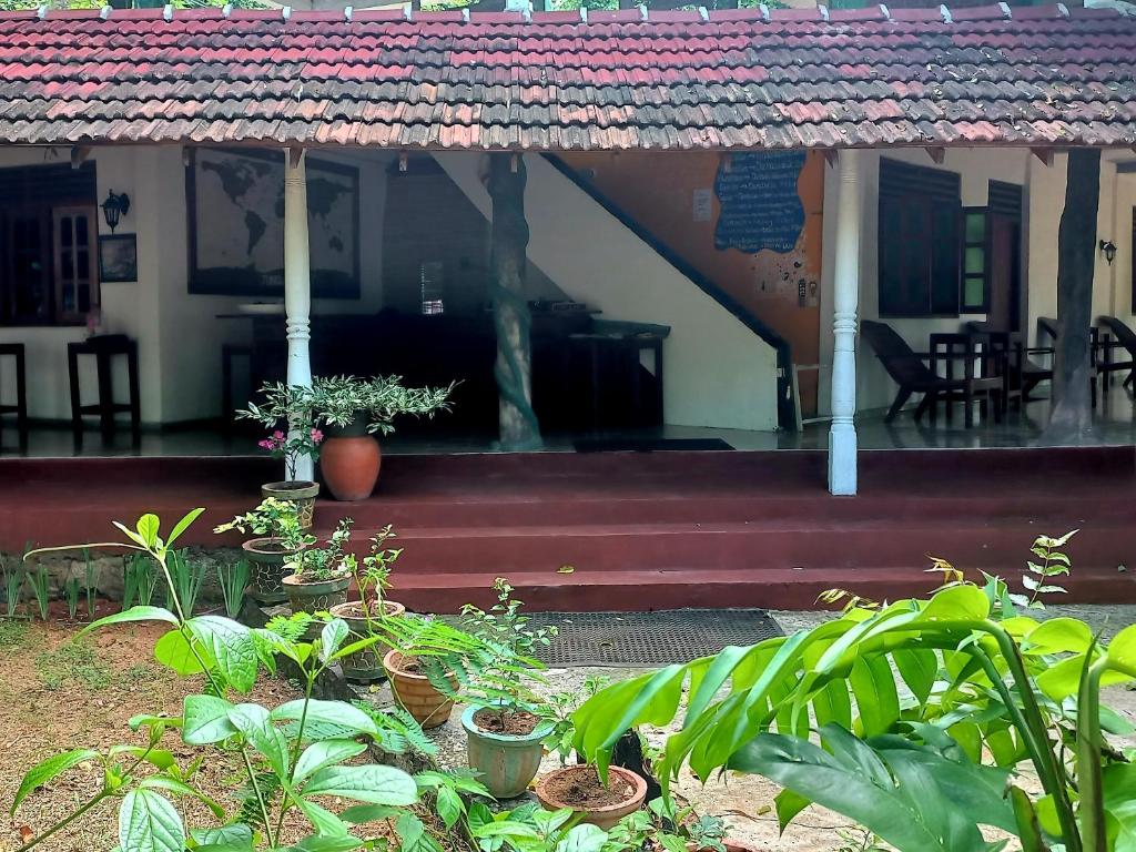 una casa con un porche con plantas delante en Eco Pavilion, en Sigiriya