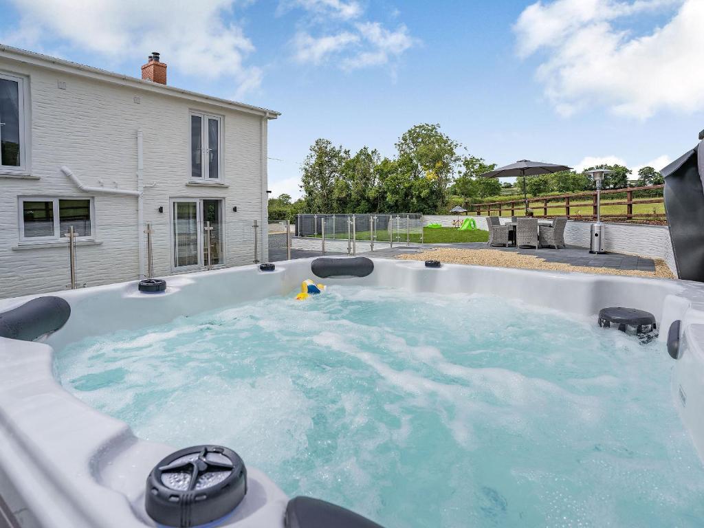 a hot tub in the backyard of a house at Penlon Cwrws in Llangynllo