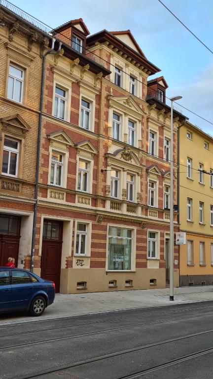 a blue car parked in front of a building at Große, moderne, helle Unterkunft mit Essküche all-in LTE in Gera