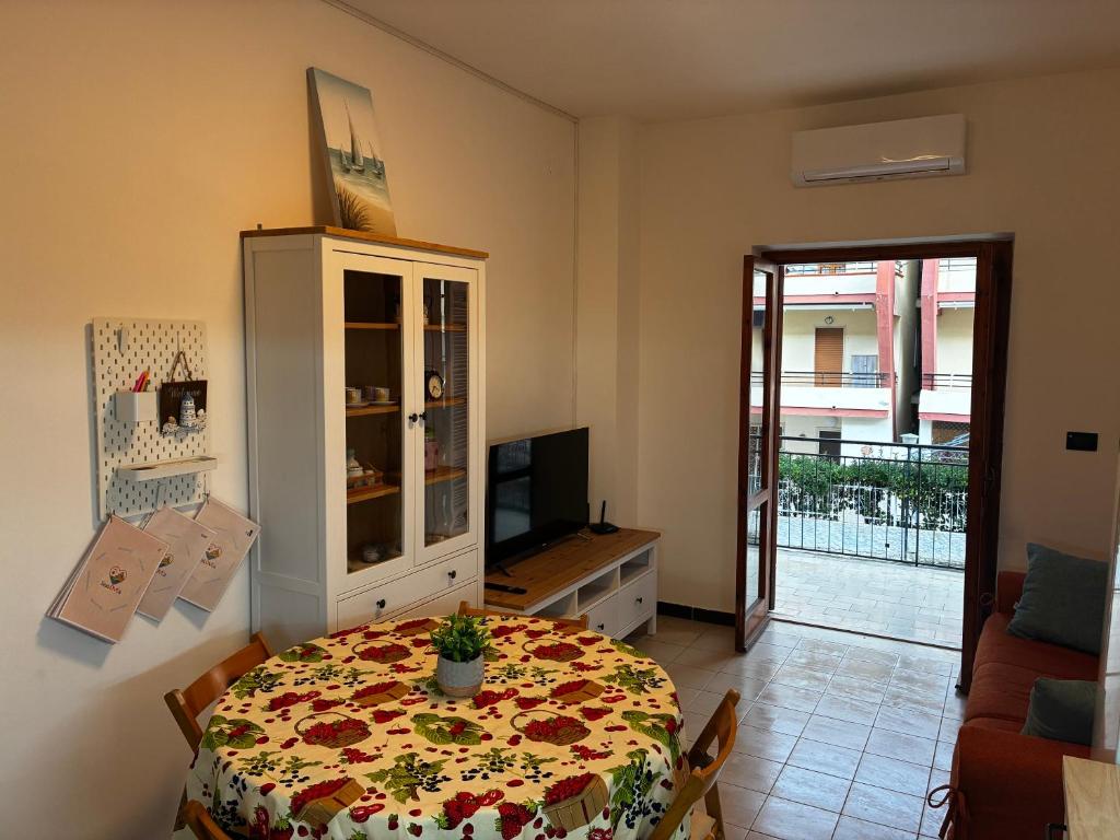 a living room with a table with a flowered table cloth at ScaLOVEa in Scalea