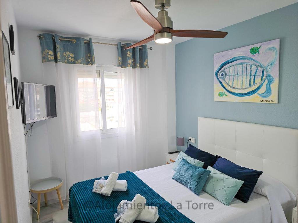 a bedroom with a bed with a ceiling fan at Laguna Beach Paradise - Alojamientos La Torre in Torrox Costa