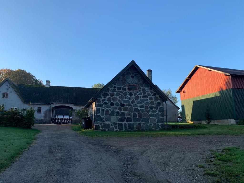 a barn with a colorful roof on a dirt road at Stone house with direct access to Haraldsted Lake in Ringsted