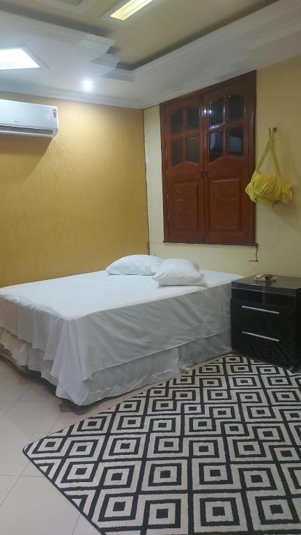 a bedroom with a bed and a wooden door at Casa da iluminada in Belém