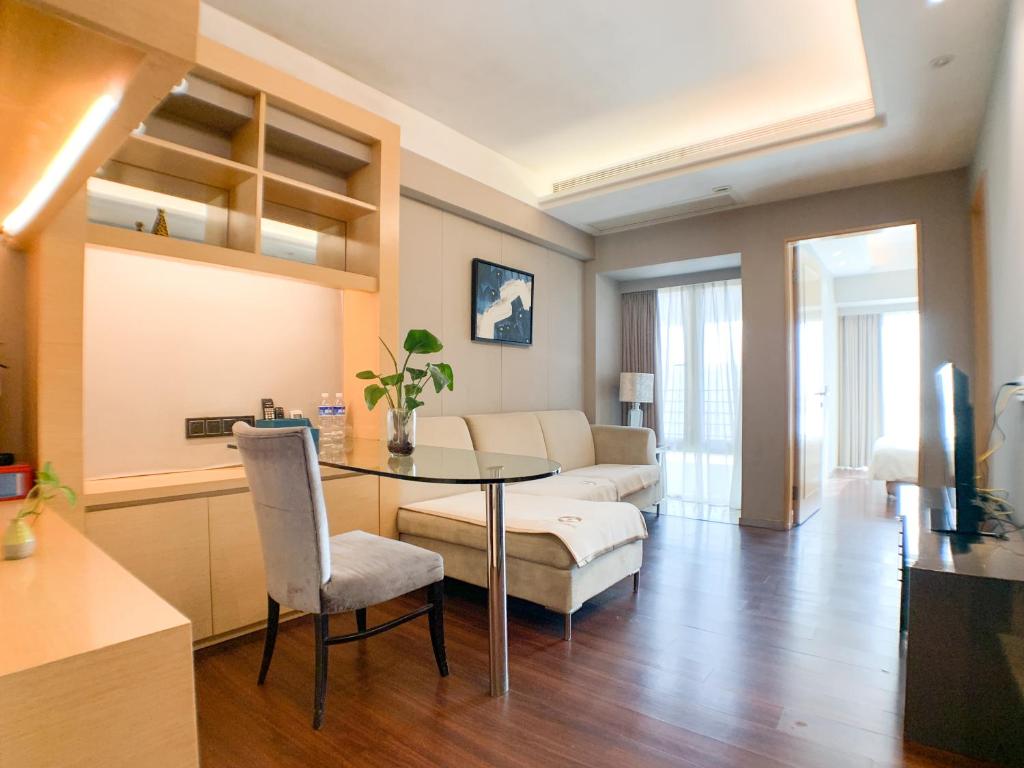 a living room with a table and a couch at Hesheng Hotel Apartment in Shenzhen