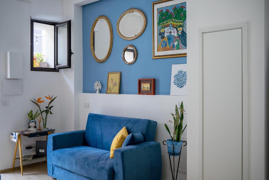 a blue living room with a blue chair and mirrors at Nicuzza in Gela
