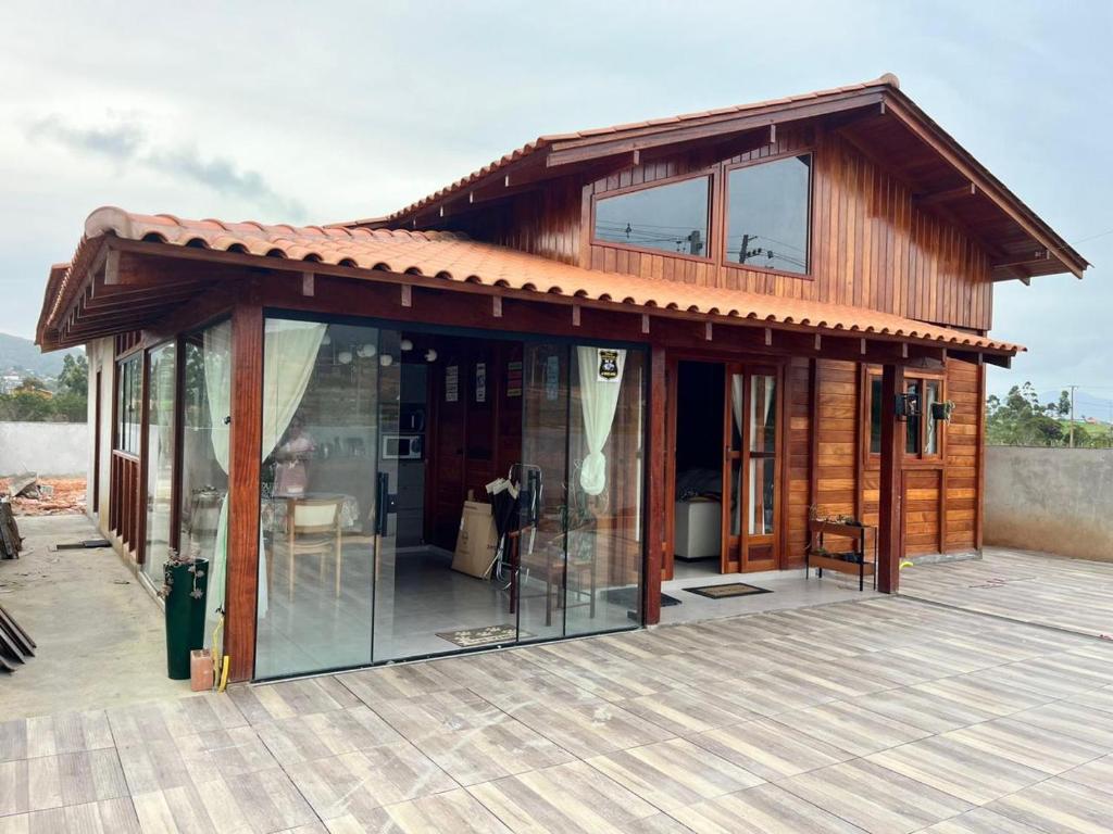 a house with glass doors on a deck at Casa de Madeira Encantadora in Governador Celso Ramos